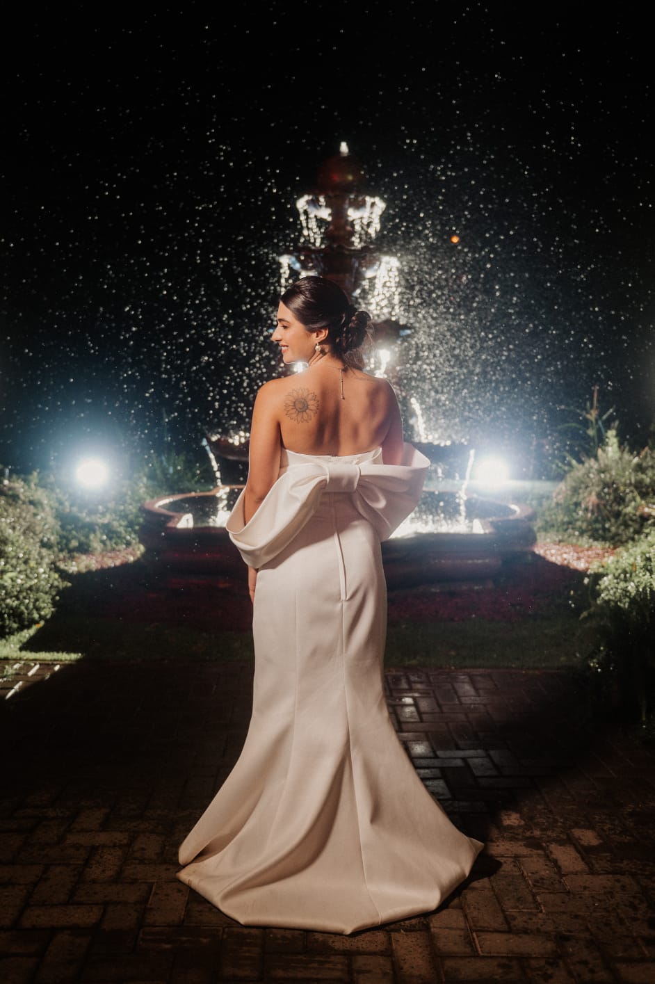 Noiva em frente à fonte iluminada à noite no Jardim Babylônia